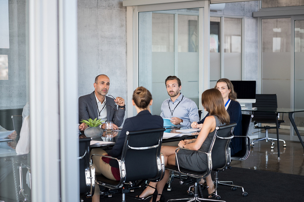 Employees meeting around a conference table.