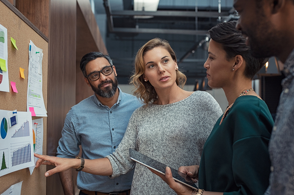 Employees looking at charts and graphs together.