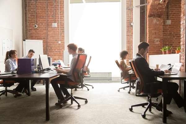 Group of people working in an open office space.